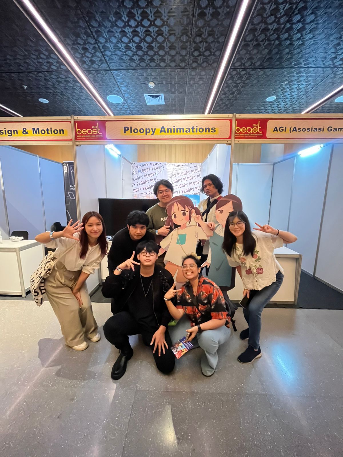 Ploopy Animations' team posing in front of our booth at BEAST festival 2024 with the Mei and clerk cutout.